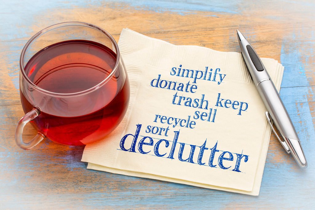 glass on napkin that reads declutter your apartment